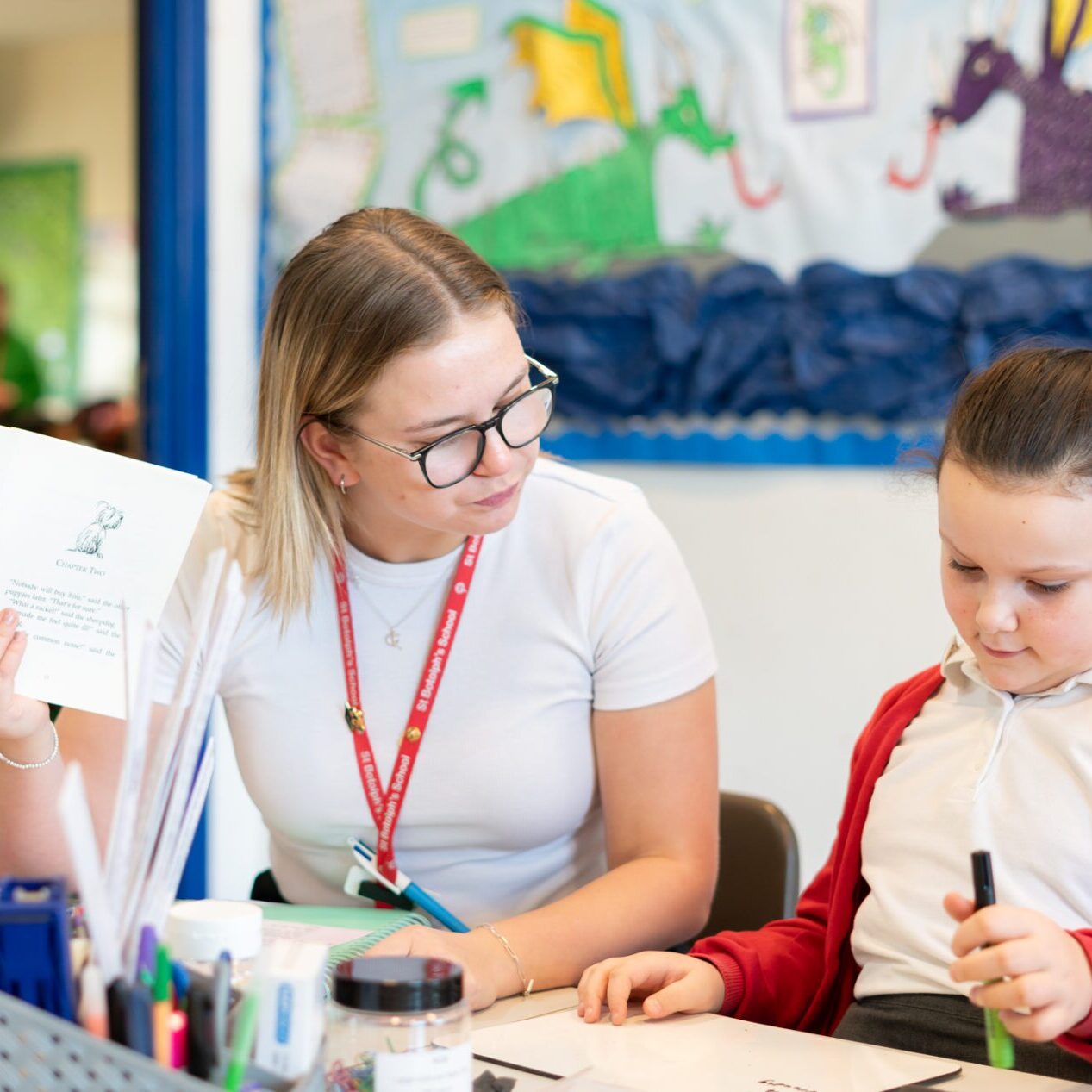 teacher at st botolphs helping a child in english